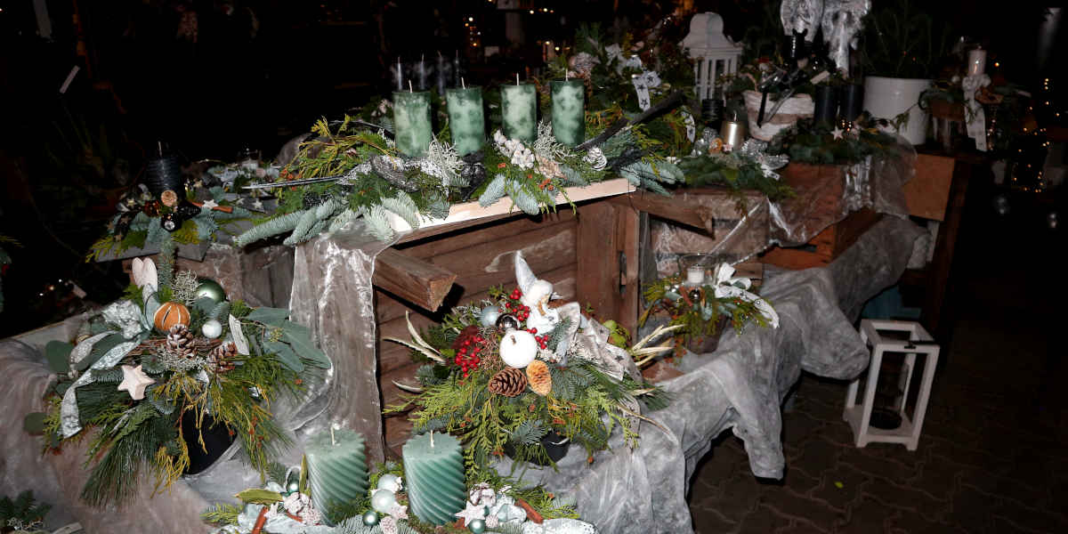 Tisch mit Adventskrenzen und Dekoration in grünen Farben.