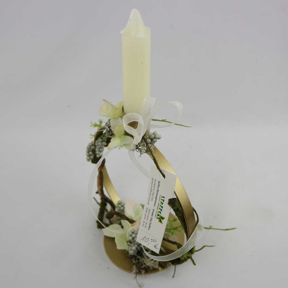 Ein runder Kerzenhalter aus Metall; dekoriert mit Kunstblumen (Hortensienblüten, Beeren, Zweige).
