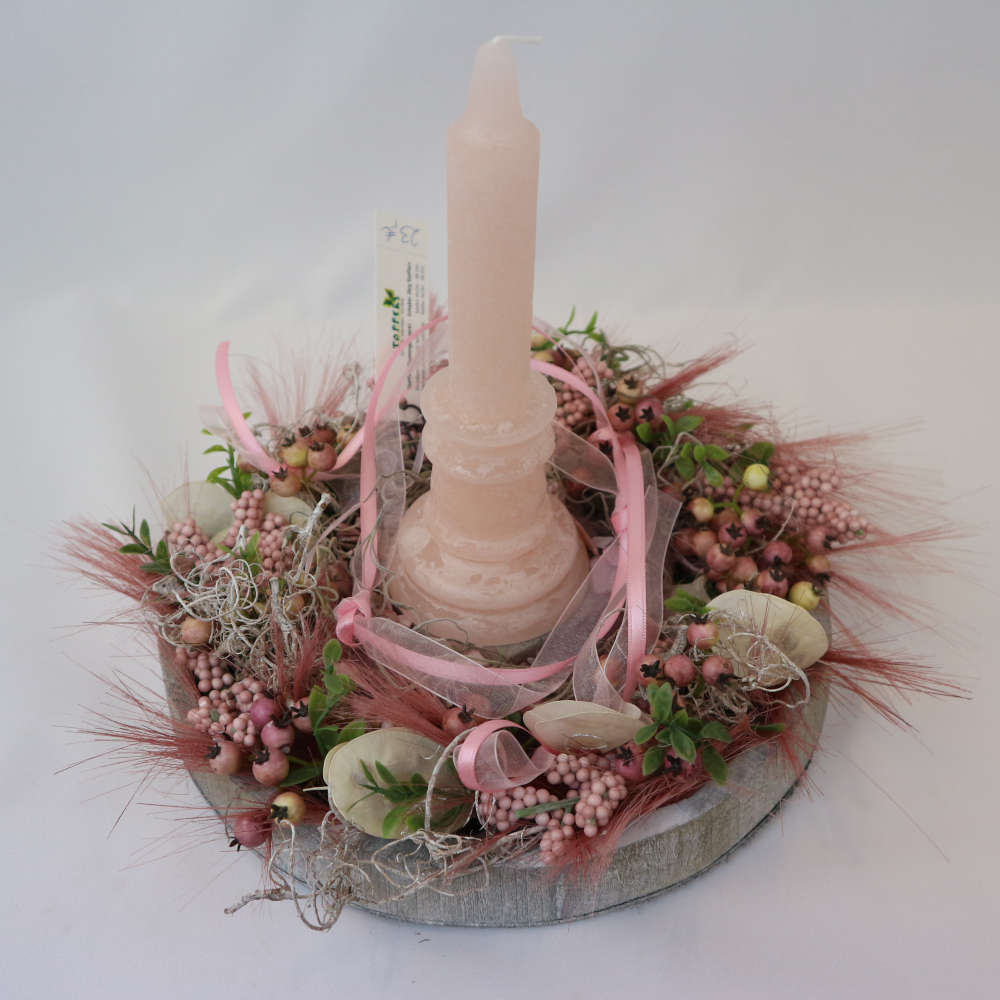  Eine rosa Kerze auf einem Tablett in Holzoptik wird von kleinen und großen Kunstbeeren umgeben. 