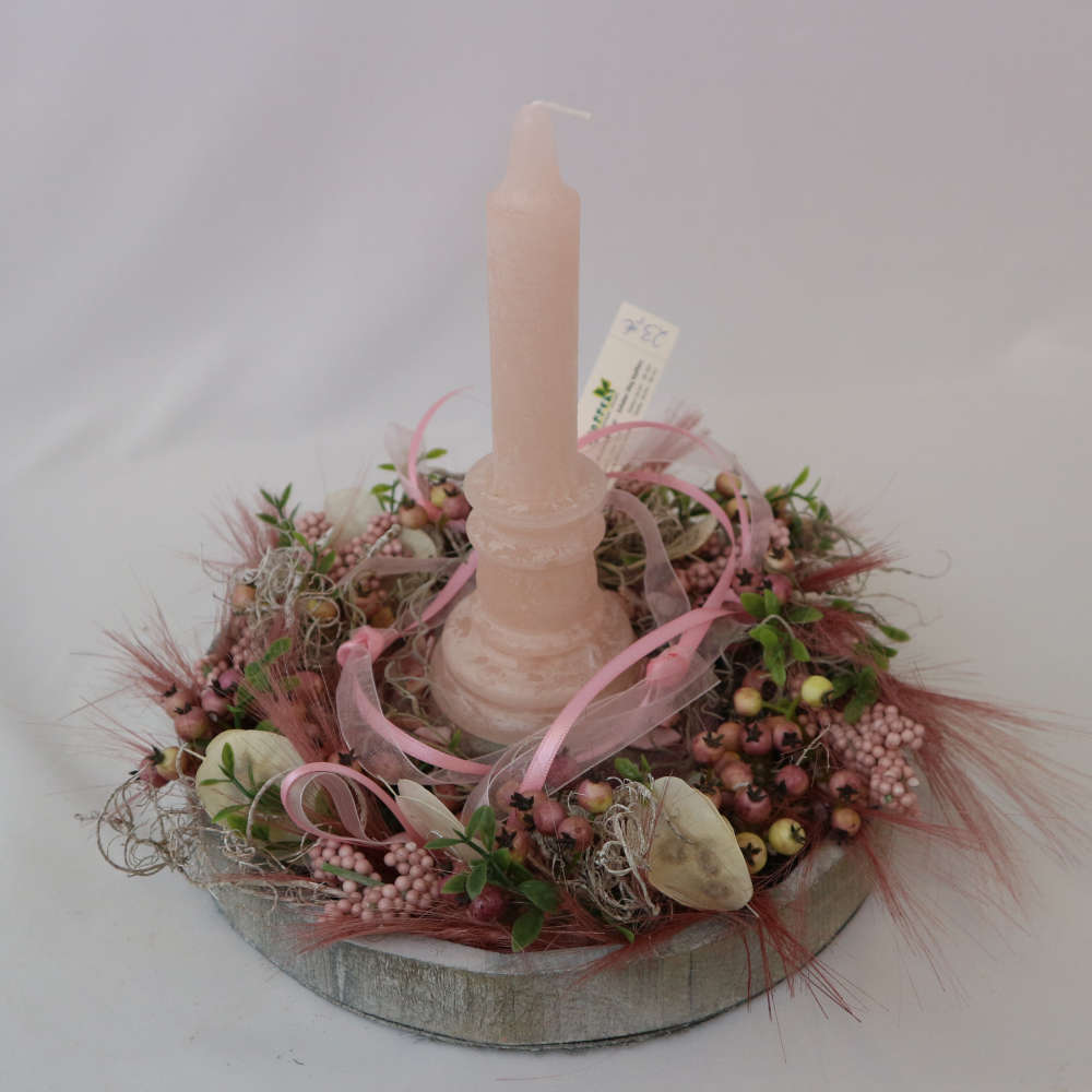 Eine rosa Kerze auf einem Tablett in Holzoptik wird von kleinen und großen Kunstbeeren umgeben.
