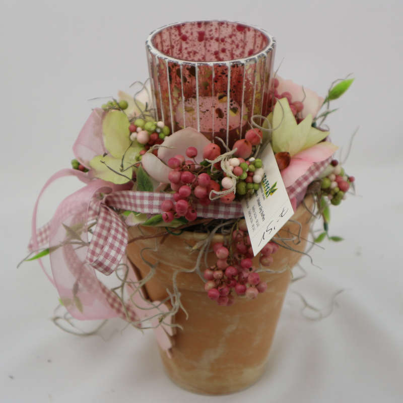 Kerzenglas im kleinen Tontopf, umgeben von Kunsthortensienblüten, Kunstbeeren und getrockneten Pfefferzweigen.