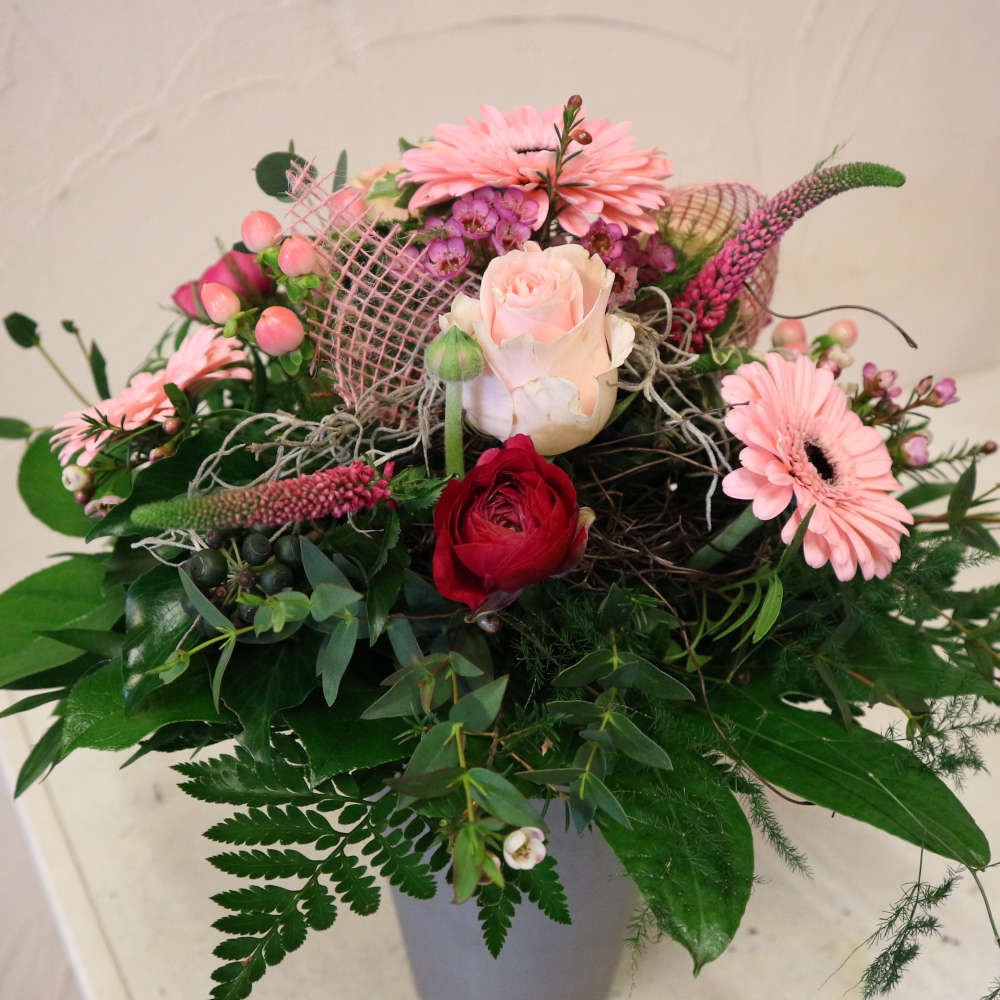 Ein großer, kompakt gebundener Blumenstrauß, bestehend aus rosa Gerbera, aufstrebenden Veroknika und rosa Rosenblüten.