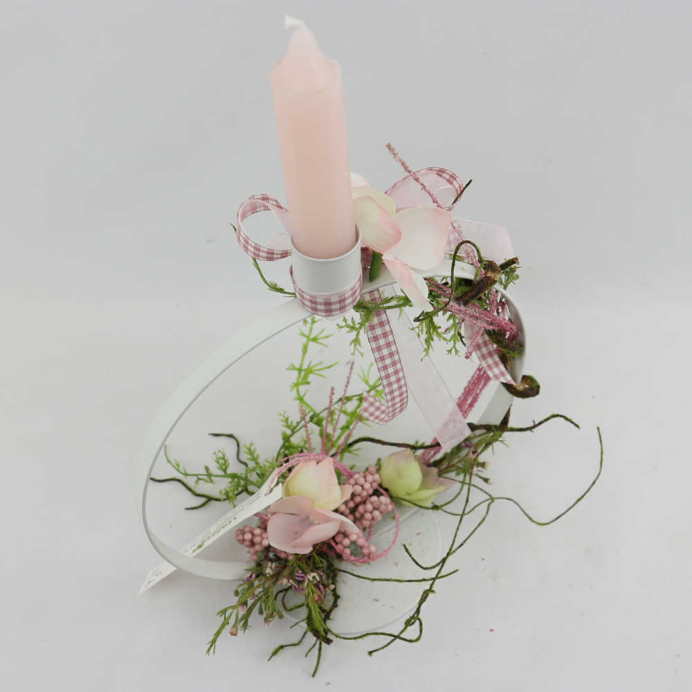 Ein schmaler, runder Kerzenhalter aus Metall in weiß. Dekoriert mit Kunstblumen.